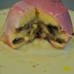 Tortini di patate e funghi in crosta di speck su fonduta di parmigiano